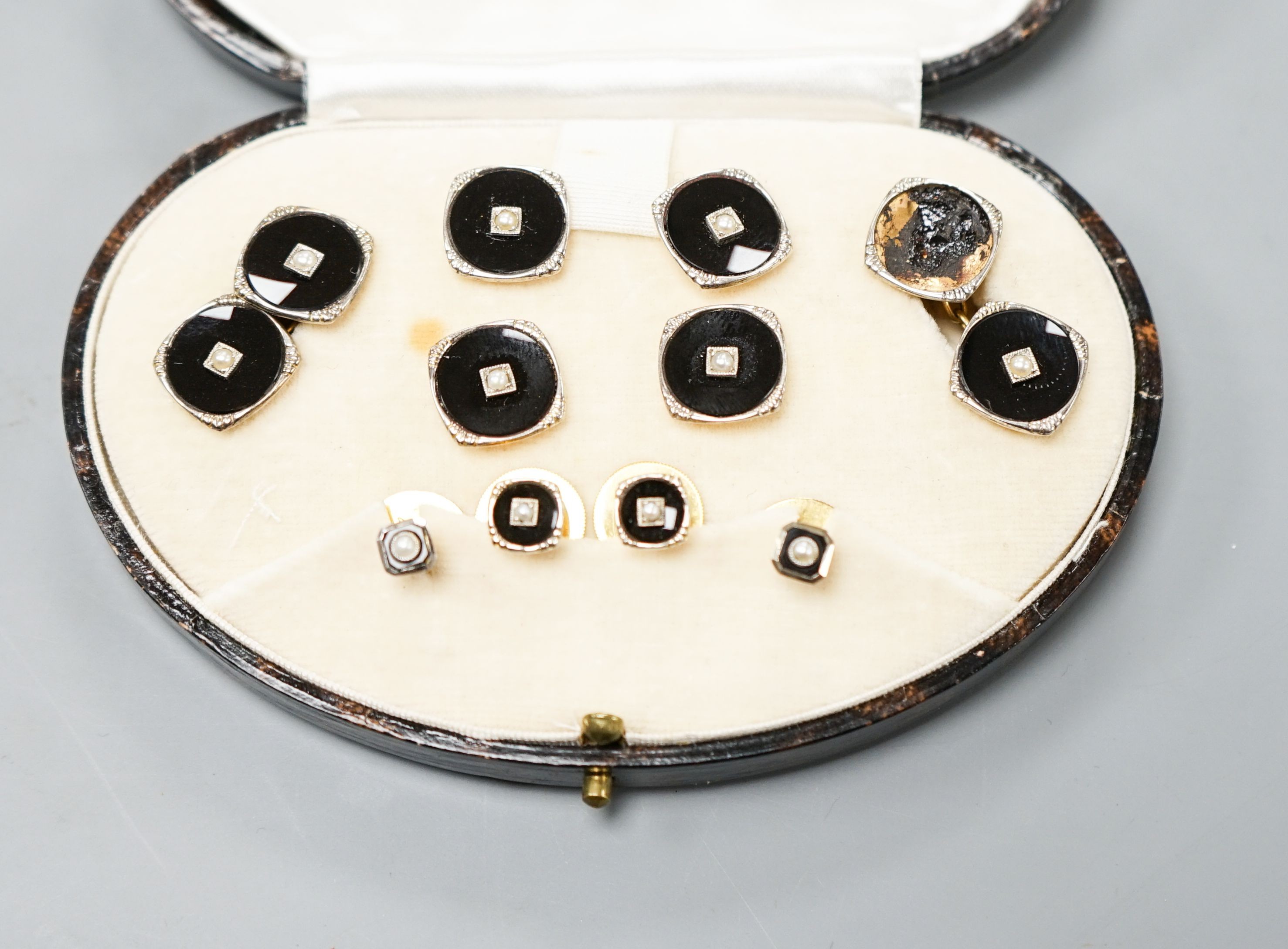 A cases 9ct, black onyx and seed pearl set ten piece dress stud set, gross weight 13 grams (a.f.).
